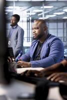 Cybersecurity technician monitoring security incidents affecting server hub workspace. System administrator in data center protecting company critical infrastructure from cyber threats photo