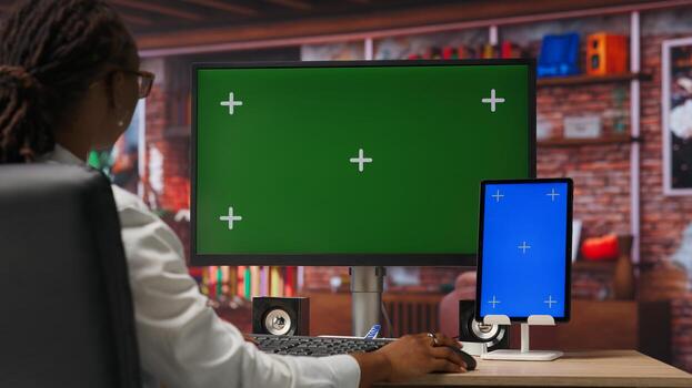 Student at home browsing internet on isolated screen computer and tablet, doing homework. Girl in apartment reading articles on chroma key PC and device for school tasks, camera B photo