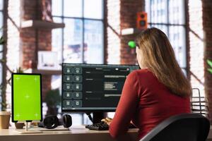 Freelancer interacting with smart AI virtual assistant next to mockup screen, using innovative chatbot web interface. Machine learning enhances productivity through advanced algorithms. photo