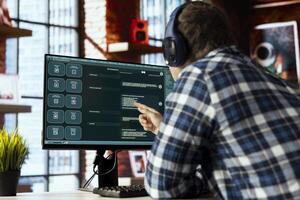 Man wearing headphones in home office uses AI LLM chatbots designed to understand human language. Worker wearing headphones using artificial intelligence chatbot trained on data photo