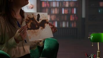 Armed forces veteran in uniform sits with a therapist during counseling, viewing a Rorschach test illustration to share feelings and discuss trauma. PTSD and shell shock syndrome. Camera A. photo