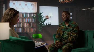 Black military officer in army uniform attends counseling session, looking distressed and opening up about post traumatic combat stress. War soldier dealing with shell shock. Camera A. photo