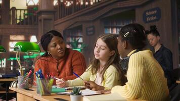 Elementary school professor engaging with girls students during private lessons, provides tutoring and guidance on specific curriculum subjects. Teacher helping classmates with ideas. Camera A. photo