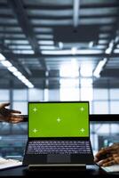 Computer scientists in data center using chroma key green screen laptop, refining server virtualization strategies. Server hub workers using mockup notebook to configure cluster nodes photo