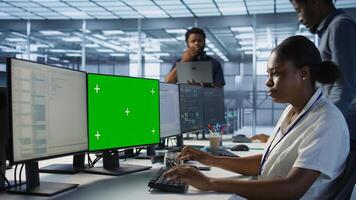 System administrator in server hub ensuring data remains shielded from potential threats using chroma key PC. Woman safeguarding data center against hackers with mockup computer, camera A photo