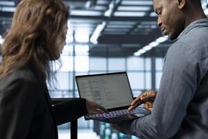 Notebook used by data center software developers reviewing equipment diagnostics. Programmers coding on notebook, adjusting server farm configurations, clearing error states, applying firmware updates photo