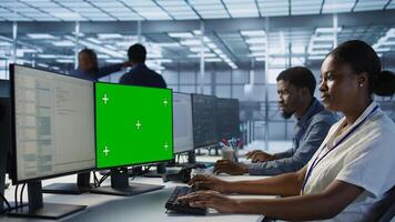 Technician using isolated screen computer, working in server farm to optimize it for data processing requirements. IT professional coding on chroma key PC in data center, camera A photo