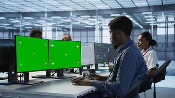 System administrator in server hub ensuring data remains shielded from threats using multi monitor mockup PC setup. Man safeguarding data center against hackers with isolated screen computer photo
