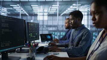 Team of engineers in data center developing and maintaining disaster recovery plans ensuring minimal downtime. Server room workers using data analytics to monitor performance, camera A photo