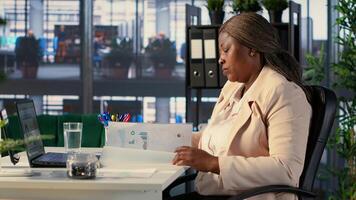 General director signing work contracts and approving employees requests, doing daily paperwork tasks for productivity. Black CEO gives authorization for leave request or license agreement. Camera A. photo