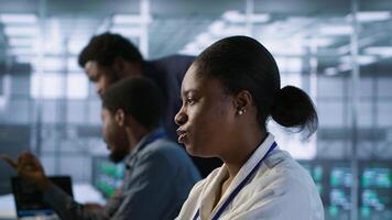 Data center software developer maintaining company network infrastructure by configuring and troubleshooting hardware. Close up of woman in server hub ensuring optimal system performance, camera A photo