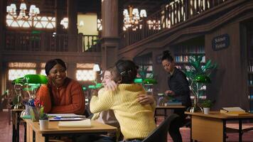 Cheerful diverse classmates sharing a high five during private lessons with tutor in the library, finishing team project. Elementary school pupils feeling satisfied with academic progress. Camera A. photo