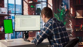 Software engineer at computer coding, creating software using isolated screen tablet. IT specialist in home office working with code editor, building applications using PC and mockup device, camera A photo