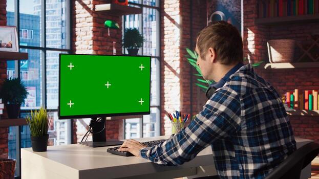 teletrabajo hombre en vivo habitación hogar oficina utilizando croma llave computadora a plan negocio desarrollo. remoto trabajador haciendo proyecto investigación, mecanografía en verde pantalla dispositivo teclado, cámara un foto