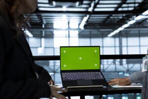 Computer scientists in data center using isolated screen mockup laptop to do network virtualization. Green screen chroma key notebook used by workers in server farm verifying rackmounts settings photo