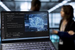 Focus on laptop used by data center system administrators using artificial intelligence neural networks. Close up of AI programming language on notebook screen used by server farm employees photo
