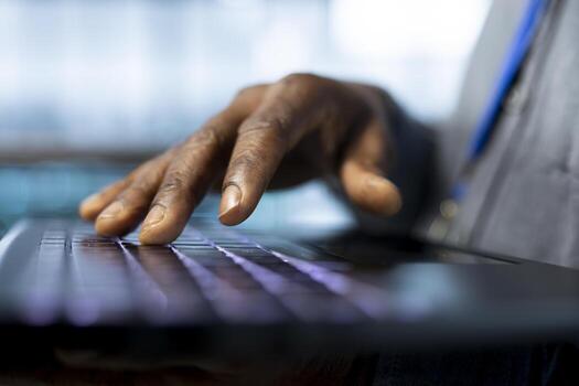 Engineer in data center typing on laptop keyboard, automating routine maintenance tasks, executing diagnostic scripts. Close up of worker using notebook, adjusting cooling and power settings photo
