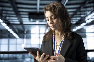 Computer scientist in data center automating routine maintenance tasks with tablet, executing diagnostic scripts. Woman using device, adjusting cooling and power settings photo