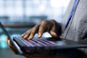 Employee in data center typing on laptop keyboard, analyzing metrics, optimizing storage volumes. Close up of worker using notebook, reviewing network paths, ensuring seamless operations photo