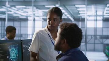Manager taking feedback from data center engineer maintaining company network infrastructure. Team leader in server hub listening worker ensuring optimal system performance, camera A photo