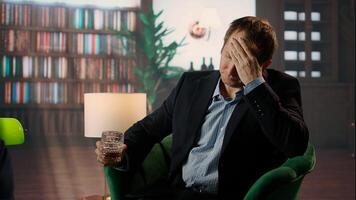 Old money elite gentleman drinking strong whiskey due to stress in a luxurious classy lounge, being dizzy with a headache. High society member getting tipsy, day drinking. Camera A. photo