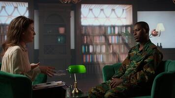 African american military trooper sharing flashbacks from the war during counseling session, tying to cure PTSD and shell shock. Army veteran deals with depression after traumatic scenes. Camera A. photo