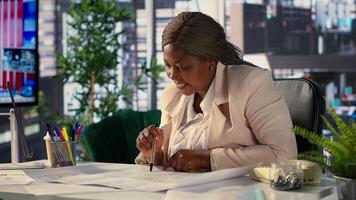 Black corporate owner drafting architectural sketches for a new office, looking to relocate startup headquarters. Collaborates with contractors to design a functional creative workspace. Camera A. photo