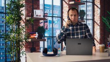 Manager at work arguing with employee during phone call after finding mistakes in spreadsheets on laptop. Team leader scolding worker during telephone call after finding errors in documents, camera A photo
