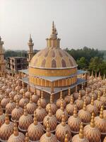 A close-up perspective of the intricately designed domes at a temple complex, nestled amidst vibrant, lush greenery in a tranquil, picturesque setting photo