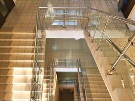 Top view of staircases with handrails and glass railings. photo