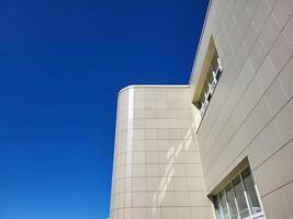 The facade of the house is made of large gray slabs on a bright sunny day against a blue sky. photo