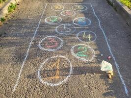 In the courtyard on the asphalt there is a drawing of classics in chalk figures in circles. photo