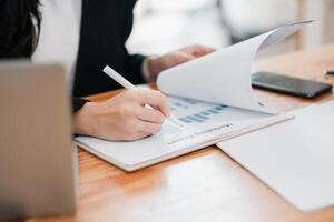 Close-up of a person reviewing a marketing report with graphs, highlighting business analysis and strategy in a modern office. photo