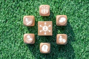 Wooden blocks on grass symbolize essential soft skills like communication, teamwork, and leadership in a modern workplace. photo