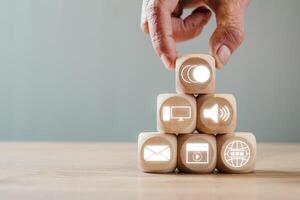 Wooden blocks with digital icons symbolize multimedia communication and technology in a modern setting. photo