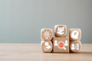 Wooden blocks with business icons symbolize the onboarding process, highlighting team integration and employee development. photo