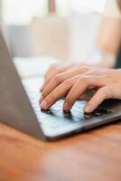 Hands typing on a laptop keyboard in a well-lit workspace, showcasing productivity and modern technology. photo