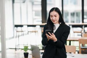 Professional Woman in Modern Office Environment Using Smartphone for Business Communication and Networking photo