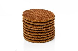 Delicious stacked caramel wafers arranged neatly on a reflective surface in a minimalist setting photo