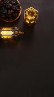 Black Clean Background With Two Lighted Gold Islamic Lanterns and A Plate of Dates Fruit Oo Kurma photo