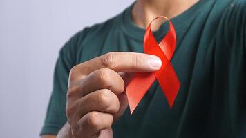 Man Holding Red Ribbon Symbolizing HIV AIDS Awareness photo