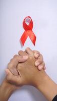 Red ribbon symbol of supporting people living with HIV AIDS photo