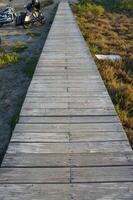 Sturdy wooden walkway leads through a serene landscape at sunset, inviting exploration and tranquility. photo