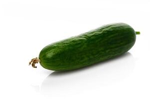 Fresh cucumber showcasing vibrant green color on white surface in a minimalist setting photo