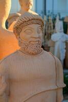 Ancient sculpture with intricate details captured during golden hour in a serene outdoor gallery photo
