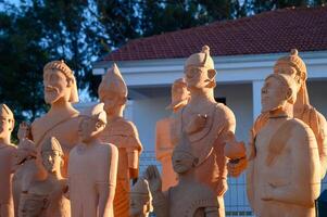 Ancient terracotta sculptures illuminated by sunset at a historic site in a serene outdoor setting photo