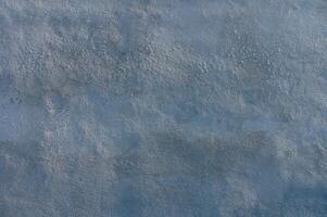 Swirling shades of blue grace the textured surface of a tranquil water body under soft sunlight photo