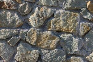 Rustic charm of a weathered stone wall in the heart of a countryside landscape under bright sunlight photo