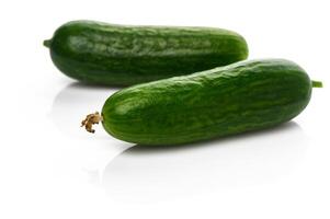 Fresh cucumbers glistening with water droplets on a white background create a vibrant visual of healthy eating photo