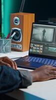 Vertical editor analyzing film montage on laptop screen before editing color grading and lighting in creative office. Post production studio employee working with raw footage on notebook, camera A video